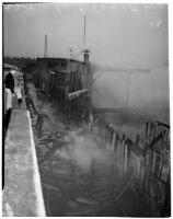 Firefighters walk through the ruins of a fire that rat Dura Steel Products Co., Los Angeles, 1940