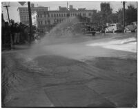 Burst fire hydrant flooding 1st and Main St. in downtown Los Angeles, circa 1940