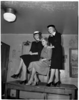 Margaret St. George, Betty Bloomquist and Rosemary Quinn pose together on top of a desk, Los Angeles, 1940