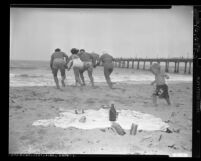 People at beach littered with trash in Los Angeles, Calif., circa 1949