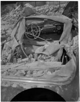 Automobile covered in rubble after swerving off the road and crashing into the side of a building, Los Angeles, 1940s