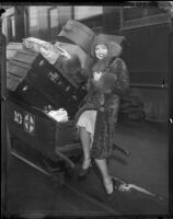 Clara Bow, with Santa Fe Railway pushcart full of luggage