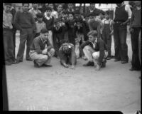 Crowd of boys watch Charles Kramer, Paul Barbata, and George Stassi compete in a marble tournament, Los Angeles, 1935