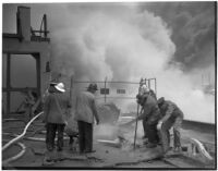 Fire fighters working to save a terminal in the L.A. Harbor which was threatened by flames when the Markay oil tanker exploded, Los Angeles, 1947