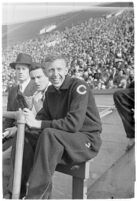 USC track athlete grinning while sitting on the sidelines at a meet, Los Angeles, 1937