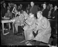 Members of the press dressed in raincoats to protect themselves from mud flying from the ring during a mud wrestling match between Sandor Szabo and Prince Bhu Pinder at Olympic Auditorium, Los Angeles, October 20, 1937