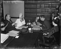 Evangelist Aimee Semple McPherson conferring with her attorneys over paperwork, Los Angeles, 1937