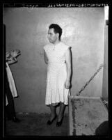 Sidney Cochin (aka The Nutty Housewife) wearing dress and heels in jail cell in Los Angeles, Calif., circa 1949