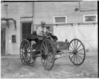 J.H. Ozmun pictured in his Model 3 Holsman "Highwheeler" car after a cross-country trip, February 16, 1936