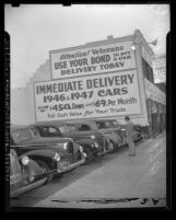 Kelley Kar Company dealership, sign on side of building reads "Attention! Veterans use your bond to buy a car" in Los Angeles, Calif., 1947