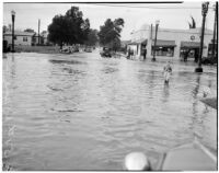 Young boy stands in a flooded street caused by heavy rainstorms, January 1940