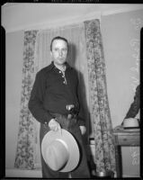 Dr. Ralph Wagner poses with a pistol and hat, Los Angeles, 1930s