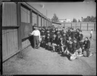 UCLA football coach William Spaulding reviews game strategy with team at Spaulding Field, Los Angeles, 1930s