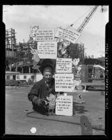 Welder Alfred Barnes displaying safety and morale signage at California Shipbuilding Corp. yard in Terminal Island, Calif., circa 1943