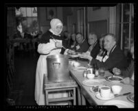 Nun of Little Sisters of the Poor serving Thanksgiving Day meal to group of men in Los Angeles, Calif., 1939