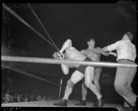 Referee getting between wrestlers Gus Sonnenberg and Baptiste Paul's battle at the Olympic, Los Angeles, 1937