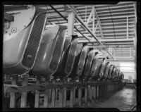 Line of Studebaker radiator grilles, affixed with hood ornaments, at Studebaker's Los Angeles assembly plant. circa January 2, 1936