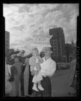 Man with toddler holding Star of David sign reading "Southland Jewish Organization" in Los Angeles, Calif., 1948