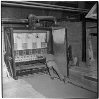 Employee loads newly made toilets into a kiln at the Universal Vitreous China Factory, Mentone, circa 1948