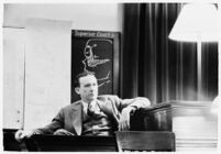 Murder suspect Robert S. James sitting on the witness stand with a plan of his house behind him, Los Angeles, 1936