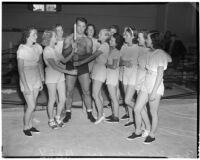 Wrestler and football player Bronko Nagurski poses with a group of women in the wrestling ring at Wrigley Field, Los Angeles, August 11, 1937