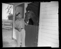 Fred Astaire with horse in stall at ranch in Los Angeles, Calif., circa 1953