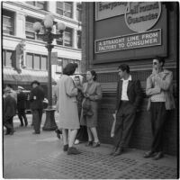 Woman talking to truant teenagers standing against a building, Los Angeles, March 1946