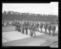 Governor Olson, Tournament of Roses Queen Sally Stanton and a cadre of police stand in the road holding a garland at dedication of Arroyo Seco Parkway, Los Angeles, 1940