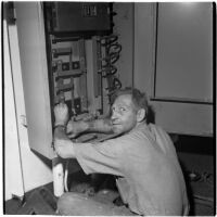 Man fixing a machine during the Army-Navy maneuvers that took place off the coast of Southern California in late 1946