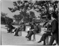 Spectators read the paper at the Santa Anita racetrack, February 22, 1937