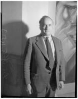 Portrait of Leo Katz standing next to his "Youth Arisen" mural panel at the Frank Wiggins Trade School, Los Angeles, 1935