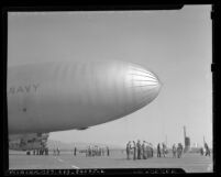 Men holding lines on U.S. Navy dirigible [blimp], California, circa 1943