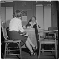 Mrs. Mallie Kerr sitting at her desk across from a teenage girl, Los Angeles, 1946