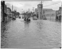 Automobiles drive through flooded streets caused by heavy rainstorms, January 1940