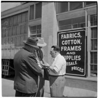Three men talking outside of a warehouse or factory, California