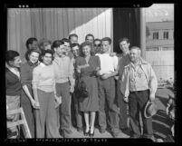 Actress Rita Hayworth receiving check for war relief from Buck-of-the-Month club members of Lockheed-Vega