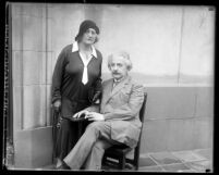 Portrait of scientist Albert Einstein seated, with his wife Elsa standing next to him, circa 1931