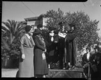 Chief Davis hands actress Gloria Swason the paid mortgage to the Bide-a-Wee home founded by Minnie Barton, Los Angeles, 1935