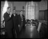 Lawyer Erwin P. Werner and Deputy Sheriff Contreras look at dart game exhibit during trial, October 1935