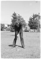 LA Daily News city editor Charles Judson demonstrates improper golf swings for a tutorial series with golfer Fay Coleman. Circa 1940