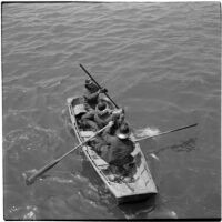 Fire fighters in a rowboat on their way to battle fires that began when the Markay oil tanker exploded in L.A. Harbor, Los Angeles, 1947