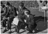 Spectators check their betting sheet on opening day of Santa Anita's fourth horse racing season, Arcadia, December 25, 1937