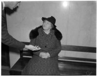 Nita Randall in court identifying the knife allegedly used by her tenant John Frank Reavis to kill Alice Burns, Los Angeles, May 1, 1940