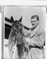 Film actor Clark Gable with his horse Beverly Hills on his ranch, Los Angeles, 1937
