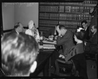 Evangelist Aimee Semple McPherson conferring with her attorneys over paperwork, Los Angeles, 1937