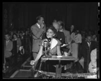 Dorothy Healey at microphone during city council debate on requiring Communists to register Los Angeles, 1950