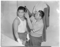 Ceferino Garcia, champion boxer from the Philippines, getting ready for a fight with his trainer, Los Angeles, circa 1938