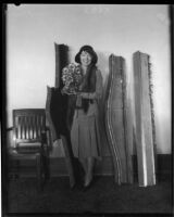 Actress Colleen Moore photographed holding peacock statuette, Los Angeles, 1930s