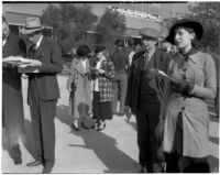 Spectators read the paper at the Santa Anita racetrack, February 22, 1937