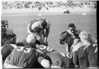 Loyola Lions in a huddle with their coaches on the Coliseum field, Los Angeles, 1937